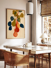 Botanical pear wall art illustration with overlapping navy, olive, and orange fruit shapes on cream, in a styled room mockup