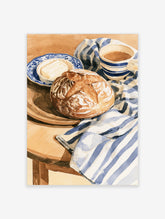 Watercolor illustration of bread, butter, and coffee on a blue and white striped cloth, ideal for kitchen wall art