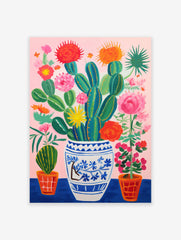 Vibrant cactus and flowers poster in a blue and white vase with pink background and orange pots.