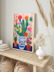 Vibrant cactus and flowers poster in a blue and white vase with pink background and orange pots. - Image 4