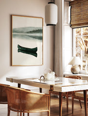 Dark green canoe floating on a calm, misty lake with reflection, minimalist watercolor landscape, in a styled room mockup