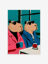 Two capybaras in sunglasses and colourful jackets sitting at a cafe table with mugs