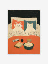 Illustration of two white cats relaxing in bed with popcorn, a book, and remote. One cat wears headphones. Cozy cat art print.