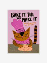Brown tabby cat in pink chef hat kneading dough, with text Bake It Till You Make It on pink background