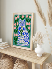 Illustrative cat wall art with blue folk-art floral patterns on a green background with pink, in an alternate framed mockup