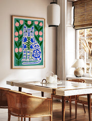 Illustrative cat wall art with blue folk-art floral patterns on a green background with pink flowers, in a styled room mockup