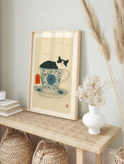 Black and white cat sleeping in a blue floral teacup with an orange tea tag, whimsical cat wall art print. - Image 3