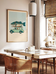 Illustrative print of black cat driving vintage car with orange and white cats, giant fish on roof, in a styled room mockup