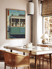 Japanese Ukiyo-e style print of many cats looking out from a green tram window under a blue sky, in a styled room mockup