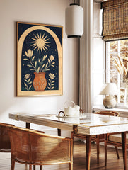 Illustrative wall art print with sun, potted white flowers, green leaves, stars, and arch on navy, in a styled room mockup