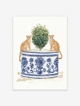 Watercolor art print of two cheetahs sitting by a green plant in a blue and white chinoiserie planter.