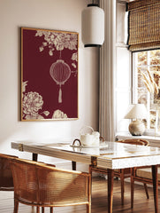 Illustrative Chinese lantern with tassel, cream botanical flowers, and foliage on a maroon, in a styled room mockup
