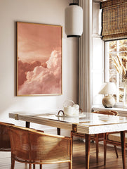 Voluminous white and pink clouds against a peach-toned sky, creating an abstract cloudscape wall, in a styled room mockup