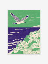 Illustrative coastal wall art with a white seagull flying over a green cliffside village and purple ocean.