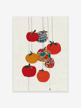 Colorful fruit wall art with red, orange, yellow, and patterned fruits hanging on thin lines against a white textured background.