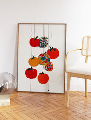 Colorful fruit wall art with red, orange, yellow, and patterned fruits hanging on thin lines against a white textured background. - Image 2