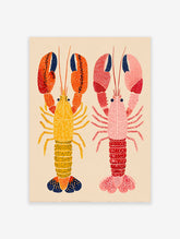 Two colorful illustrative lobster wall art prints, one yellow and orange, one pink and red, on a light beige background.