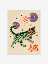 Green tabby cat reaching for purple planets with orange comet trails and red kanji on beige background
