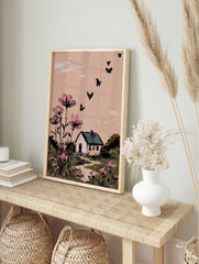 Illustrative wall art with pink cosmos flowers, a white house, and black butterflies against, in an alternate framed mockup