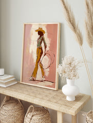 Illustrative cowgirl silhouette art print in a hat, green shirt, ochre trousers, holding a, in an alternate framed mockup