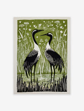 Two black and white cranes in reeds and water, with white hearts on a green background, in a linocut style