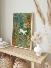 Illustrative wall art of a cream big cat walking on a branch amidst lush green and peach, in an alternate framed mockup