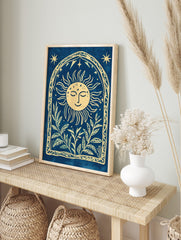 Cyanotype-style wall art with smiling sun, stars, and botanical leaves within an arched, in an alternate framed mockup
