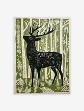Black deer art print in a linocut style, standing in a green and white forest with stylized trees and foliage.
