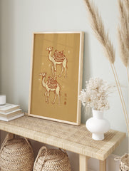 Two illustrated desert camels with decorative saddles, crescent moon, and stars on a beige, in an alternate framed mockup