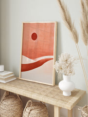 Abstract desert landscape with a dark red sun and layered terracotta sand dunes in a, in an alternate framed mockup