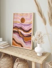 Abstract dot art print of a desert sunset with a large brown sun, pink, purple, and orange, in an alternate framed mockup