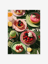 Overhead view of colorful berry tarts, cakes, and juice on plates surrounded by tropical leaves, perfect for dessert wall art.