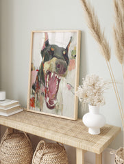 Abstract painting of a Doberman dog with wide open mouth and bared teeth in dark grey, pink, in an alternate framed mockup