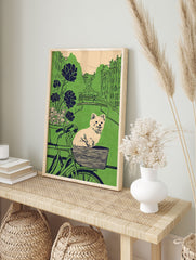Illustrative dog art print featuring a fluffy dog in a bicycle basket, with a green city canal and buildings in the background. - Image 3