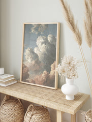 Painterly cloud study art print with white, grey, and pink clouds against a blue sky, in an alternate framed mockup