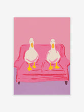 Two white ducks with yellow beaks and feet sitting on a pink couch, illustrated wall art print against a pink background.