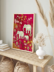 Illustrative elephant family (two adults, one calf) amidst pink and gold flowers on a magenta, in an alternate framed mockup