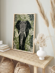 Linocut style elephant wall art print with tropical leaves in green, white, and black tones, in an alternate framed mockup