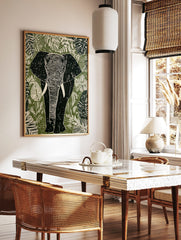 Linocut style elephant wall art print with tropical leaves in green, white, and black tones, in a styled room mockup