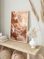 Close-up of voluminous, textured clouds in warm peach and cream tones filling the sky, in an alternate framed mockup