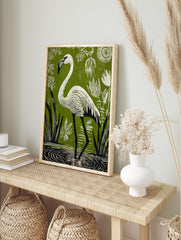White flamingo in linocut style, wading in water with green background, white plants, and, in an alternate framed mockup