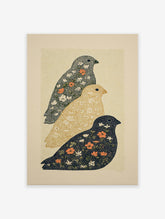 Three stylized floral bird wall art prints in dark blue, golden yellow, and grey with white and orange flowers on a speckled background.