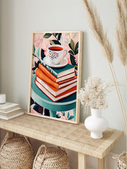 Floral teacup on saucer, stacked books, teal table, pink botanical background still life print, in an alternate framed mockup