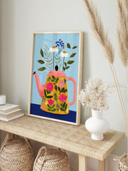 Illustrative print of a floral teapot with pink, white, and blue flowers, green leaves, on light blue background, in an