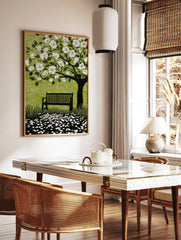 Linocut style print of a flowering tree with white blossoms, a dark bench, and scattered petals on, in a styled room mockup