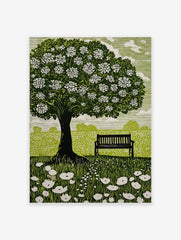 Linocut style print of a flowering tree, park bench, and wildflowers in a green field with white sky
