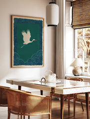 White crane flying over dark teal-green background with patterned blue-teal border and lower section, in a styled room mockup
