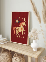 Folk art illustration of a cream horse with coral mane and tail, surrounded by stars and a, in an alternate framed mockup