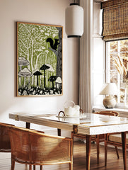 Linocut-style forest art print with black squirrel, green trees, and white mushrooms on a green, in a styled room mockup