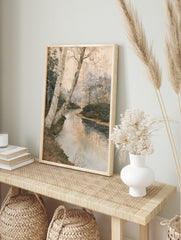 Watercolor style forest landscape painting with a winding stream and birch trees in the, in an alternate framed mockup